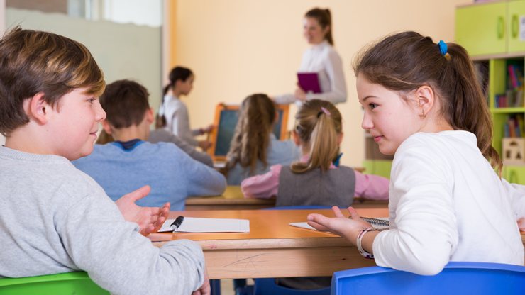 Schüler unterhalten sich in der hinteren Reihe im Klassenzimmer