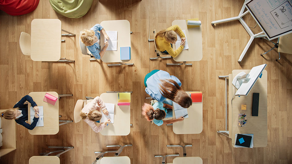 IQB Bildungstrends 2021 Lehrerin hilft Schülern im Klassenzimmer