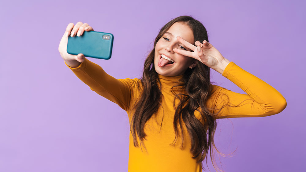 Mädchen mit Handy macht ein Selfie